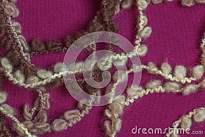 Fringe of a warm beige woolen scarf on a lilac-burgundy background Stock Photo