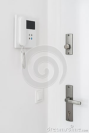 Front door with handle and keyhole and intercom system with handset on wall Stock Photo