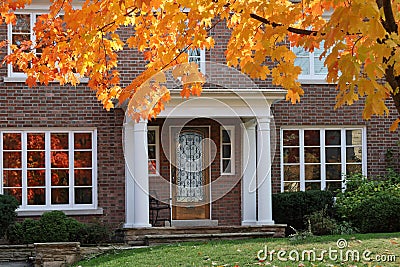front door with maple tree in brilliant fall color Stock Photo