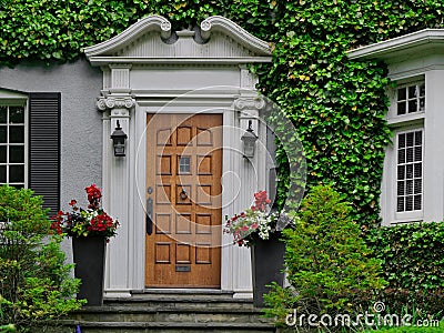 Front door of traditional older home, surrounded by vines Stock Photo