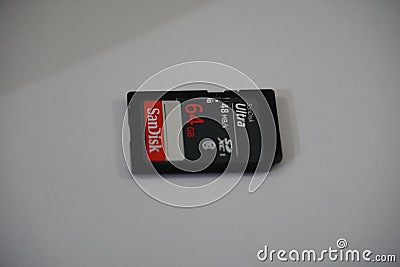 Front of 64 GB SanDisk SD memory card on white isolated background. Sandisk Ultra Micro SD card adapter is used for camera and Editorial Stock Photo