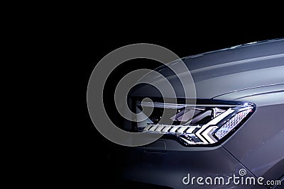 Front headlight with LED xenon light of grey modern EV Car on black colour background Stock Photo