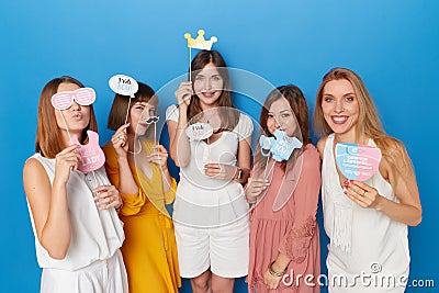 Front view of a group of joyful women to have gender reveals envent, isolated blue background. Copy space. Stock Photo