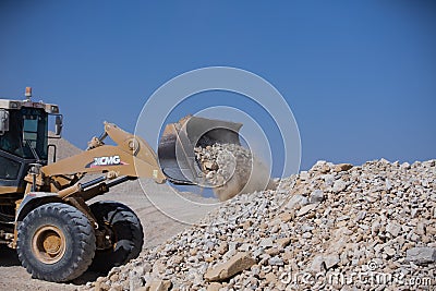 Front loaders disposing rocks in quarry area Editorial Stock Photo