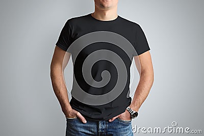 Front mockup black T-shirt on a young guy isolated on a gray ba Stock Photo