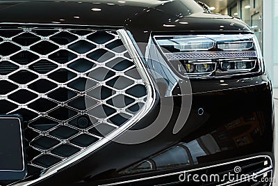 The front of a modern car with a headlight and grille. Auto front view Stock Photo