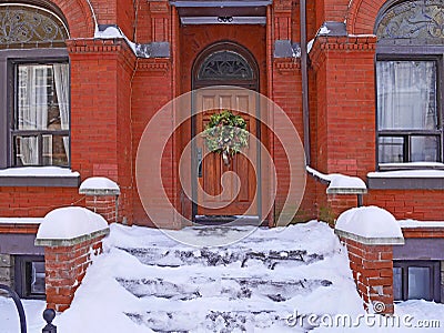 Front steps of old brick house covered in snow Stock Photo