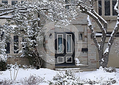 Stone fronted snow covered house Stock Photo