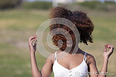 Front view of a beauty mixed race african american woman with hair blowed in air smiling at camera dancing in movement Stock Photo