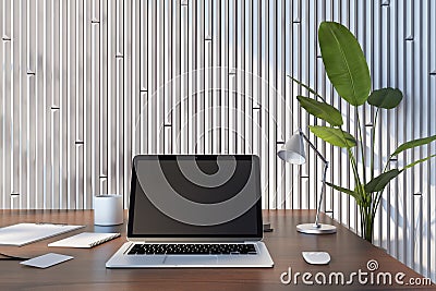 Front view on blank dark modern laptop monitor with blank place on brown wooden table with notebooks and coffee mug on green plant Editorial Stock Photo