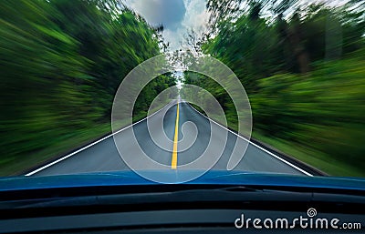 Front view of blue car driving with fast speed on the middle of asphalt road with white and yellow line of traffic symbol Stock Photo