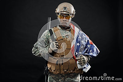 Brave African soldier posing with national flag on shoulder. Stock Photo