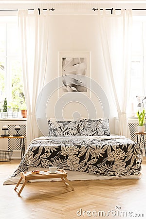 Front view of a double bed with floral sheets, graphic on the wa Stock Photo