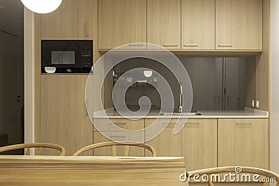 Front view of double modern kitchen in oak and white colors with dining area Stock Photo