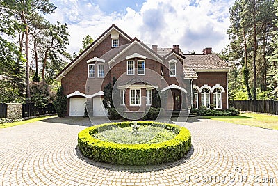 Front view of a driveway with a round garden and big, english st Stock Photo