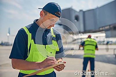 Serious aircraft technician filling out a form Stock Photo