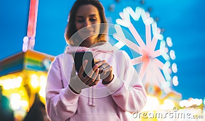 Front view girl pointing finger on screen smartphone on defocus background bokeh light in evening street attraction, woman using Stock Photo