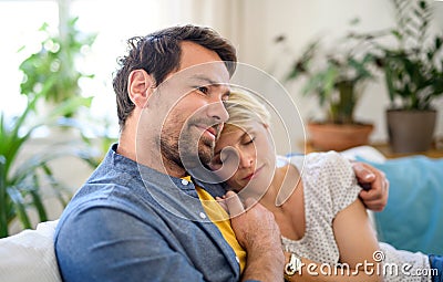 Happy couple in love sitting indoors at home, hugging. Stock Photo
