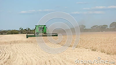 A front on view of a header being used on a grain farm to harvest ripe barley Stock Photo
