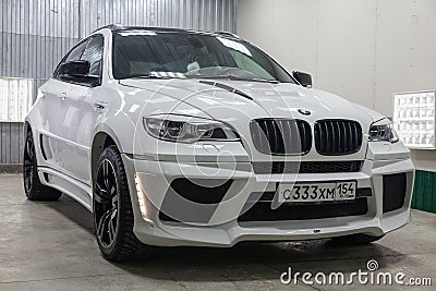 Front view of luxury very expensive new white BMW X6 M Lumma CLR tuning car stands in the washing box waiting for repair in auto Editorial Stock Photo