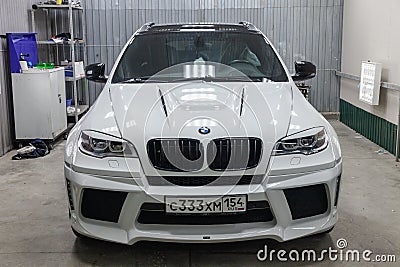 Front view of luxury very expensive new white BMW X6 M Lumma CLR tuning car stands in the washing box waiting for repair in auto Editorial Stock Photo