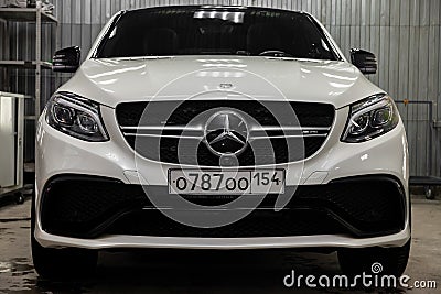 Front view of luxury very expensive new white Mercedes-Benz GLE Coupe AMG 63s car stands in the washing box waiting for repair in Editorial Stock Photo