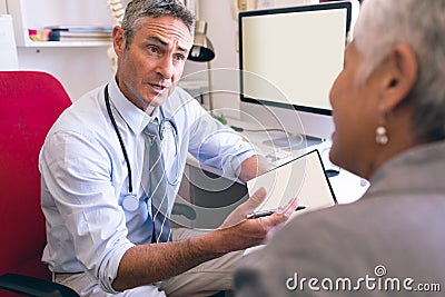 Male doctor and senior woman interacting with each other Stock Photo
