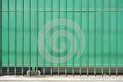 Front view of metal green automatic sliding gate door with spike pattern in front of modern house Stock Photo