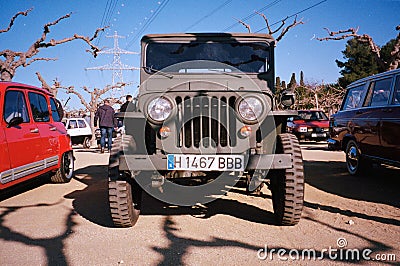 Front view of an old Willys Jeep MB military all-terrain truck parked near other cars Editorial Stock Photo
