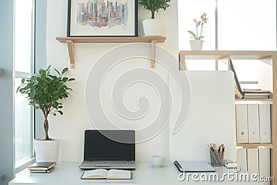 Front view picture of studio workplace with blank notebook, laptop. Designer comfortable work table, home office. Stock Photo