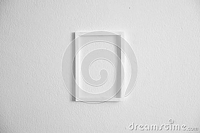 front view of single vertical photo frame hanging on clean white cement wall Stock Photo