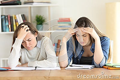 Two fatigued students studying hard Stock Photo