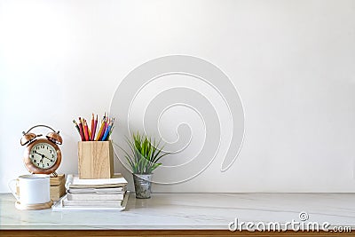 Front view of white desk with coffee mug and house plant. workspace and copy space Stock Photo