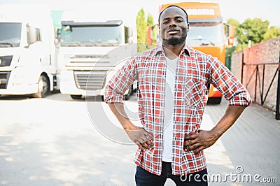 Front view. Young african truck driver is with his vehicle at daytime. Stock Photo