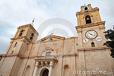 The frontal view of ancient Saint Johns Cathedral Museum in Valletta, Malta with the famous clock Stock Photo