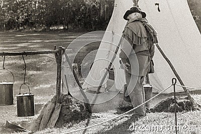 Black and white of reenactor tending to his boiling water Editorial Stock Photo