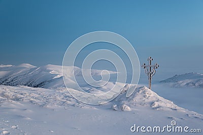 Frosted cross in snow covered mountains Stock Photo