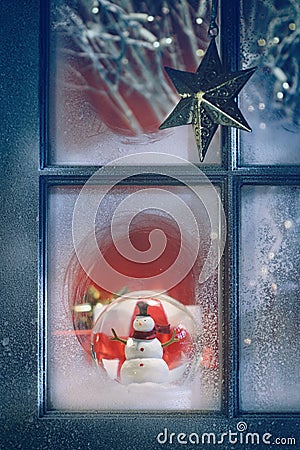 Frosted window with Christmas decorations inside Stock Photo