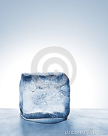 Frosty cold blue ice block melts on scratched steel surface Stock Photo