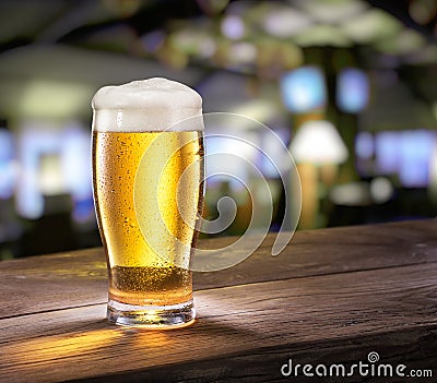 Frosty glass of light beer on the bar counter. Stock Photo