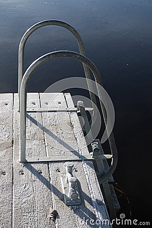 frosty jetty with a ladder leading into the water Stock Photo