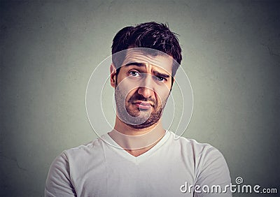 Frowning young man thinking expressing doubts and concerns Stock Photo