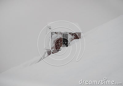 Frozen cabin in profile view on the snow slope of mountain Stock Photo