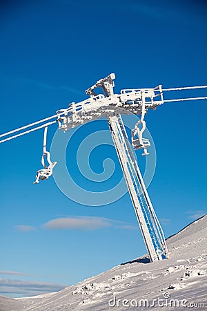 Frozen chair lift at snow resort in winter mountains on sunny da Stock Photo