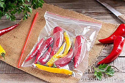 Frozen chili pepper on a wooden board on the table. Frozen vegetables. Frozen food Stock Photo