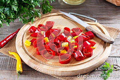 Frozen chili pepper on a wooden board on the table. Frozen vegetables. Frozen food Stock Photo