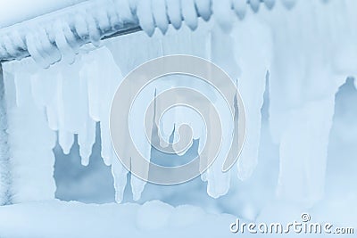 Frozen fence in winter. Huge icicles Stock Photo