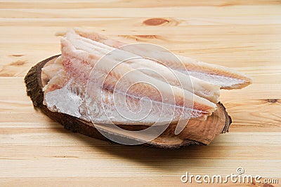 Frozen fillet of pangasius on wooden plate Stock Photo