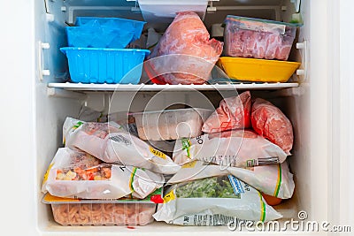 Frozen foods in the home refrigerator. Long-term storage of food. The inscriptions in Russian Editorial Stock Photo