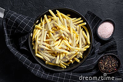 Frozen French fries in a frying pan. Black background. Top view Stock Photo